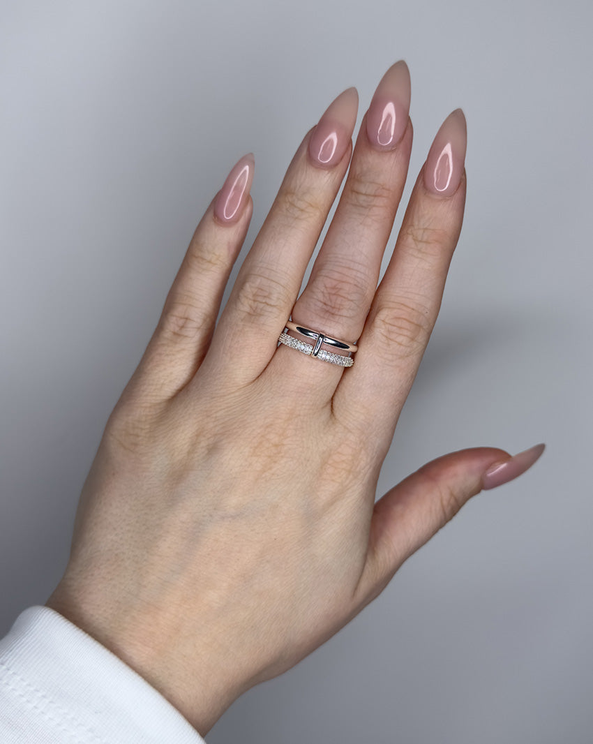 Linked ring with 2 bands linked by a connector bar. Set with imitation diamonds. 14k gold plate over recycled brass.