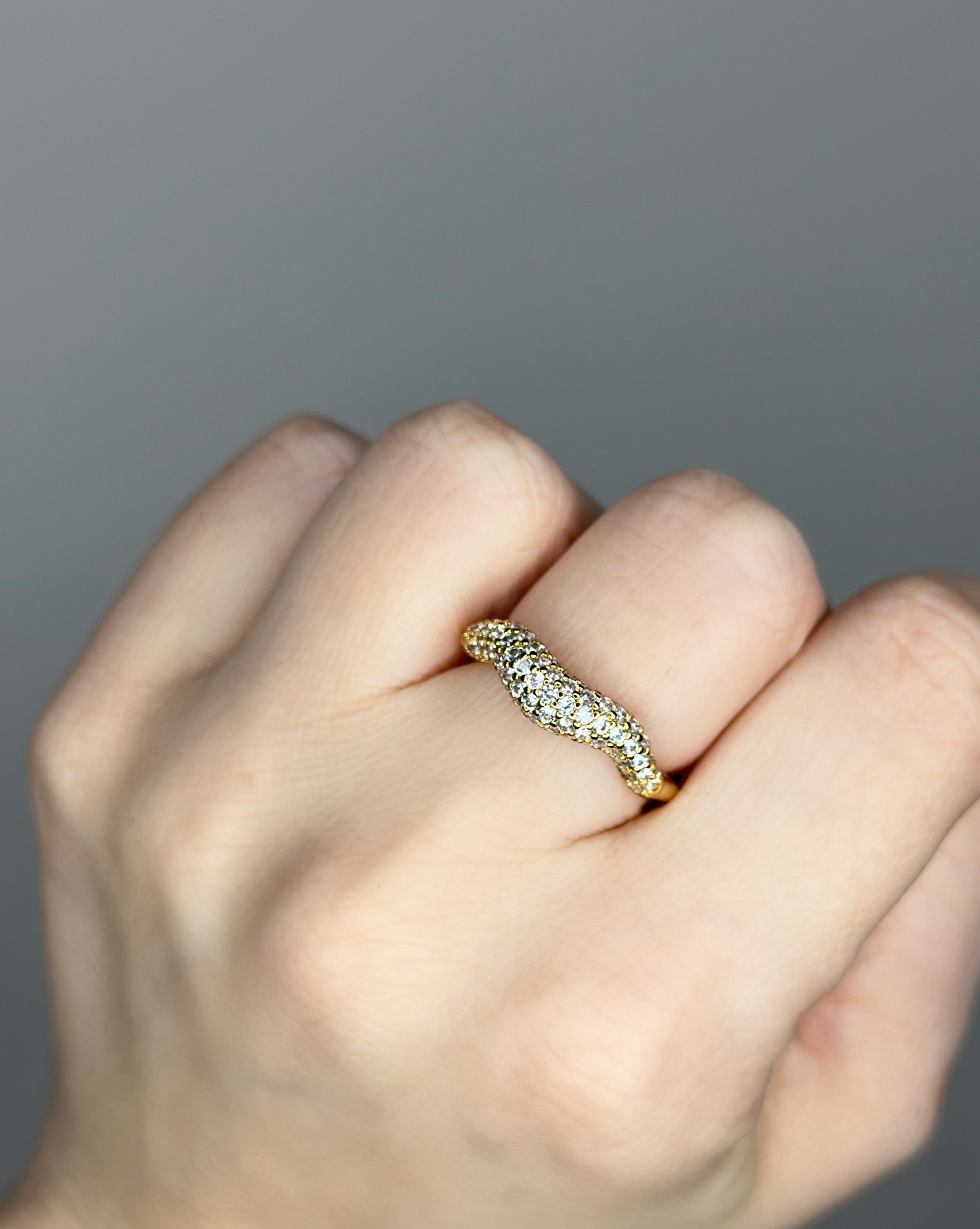 Liquid ring design with imitation diamonds. 14k gold plate over recycled brass.