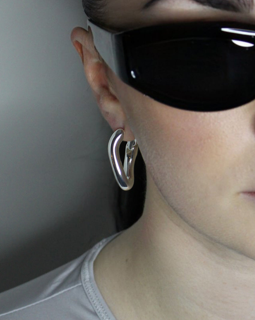 Hoop earrings in liquid twist design. Sterling silver plate over recycled zinc.
