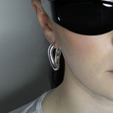 Hoop earrings in liquid twist design. Sterling silver plate over recycled zinc.