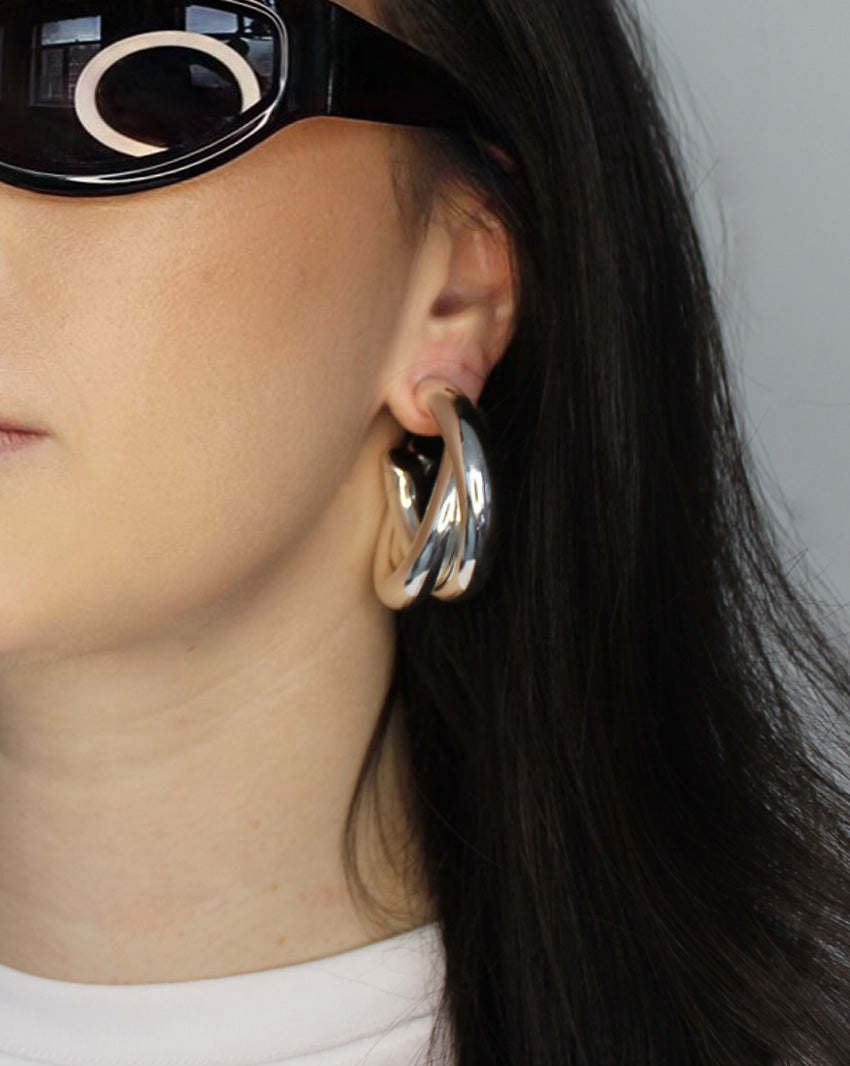 Hoop earrings in cross twist design. Lightweight hollow tube design with earring post. Sterling silver plate over recycled brass.