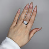 Liquid ring design with pear shape imitation diamond. Sterling silver plate over recycled brass.