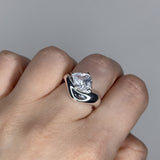 Liquid ring design with pear shape imitation diamond. Sterling silver plate over recycled brass.