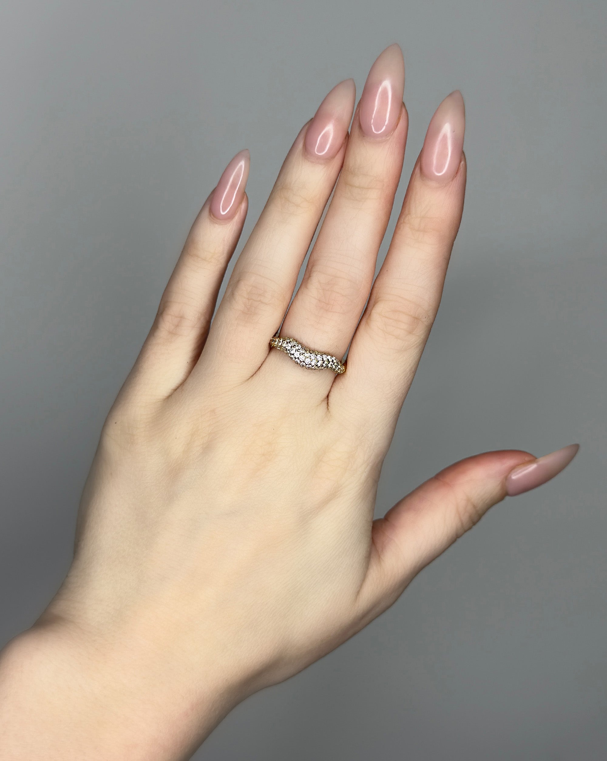 Liquid ring design with imitation diamonds. 14k gold plate over recycled brass.