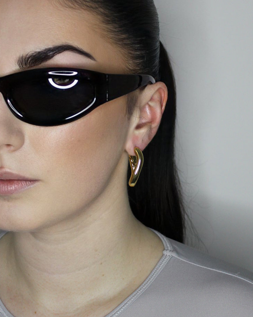 Hoop earrings in liquid twist design. 14k gold plate over recycled zinc.
