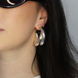 Hoop earrings in cross twist design. Lightweight hollow tube design with earring post. Sterling silver plate over recycled brass.